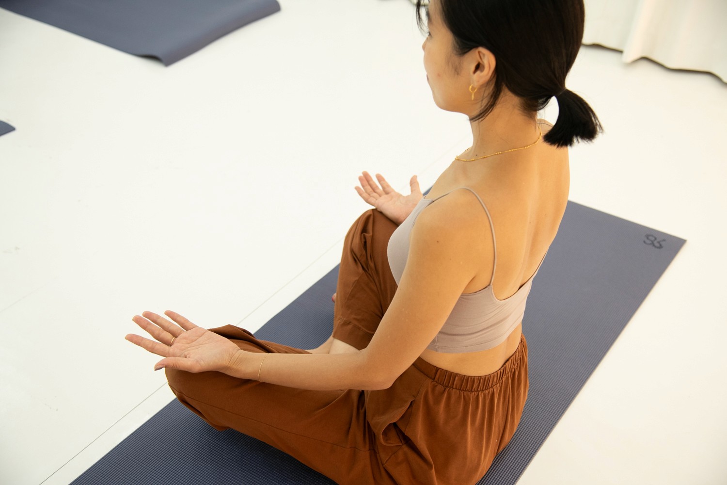 woman doing yoga meditation on brown parquet flooring