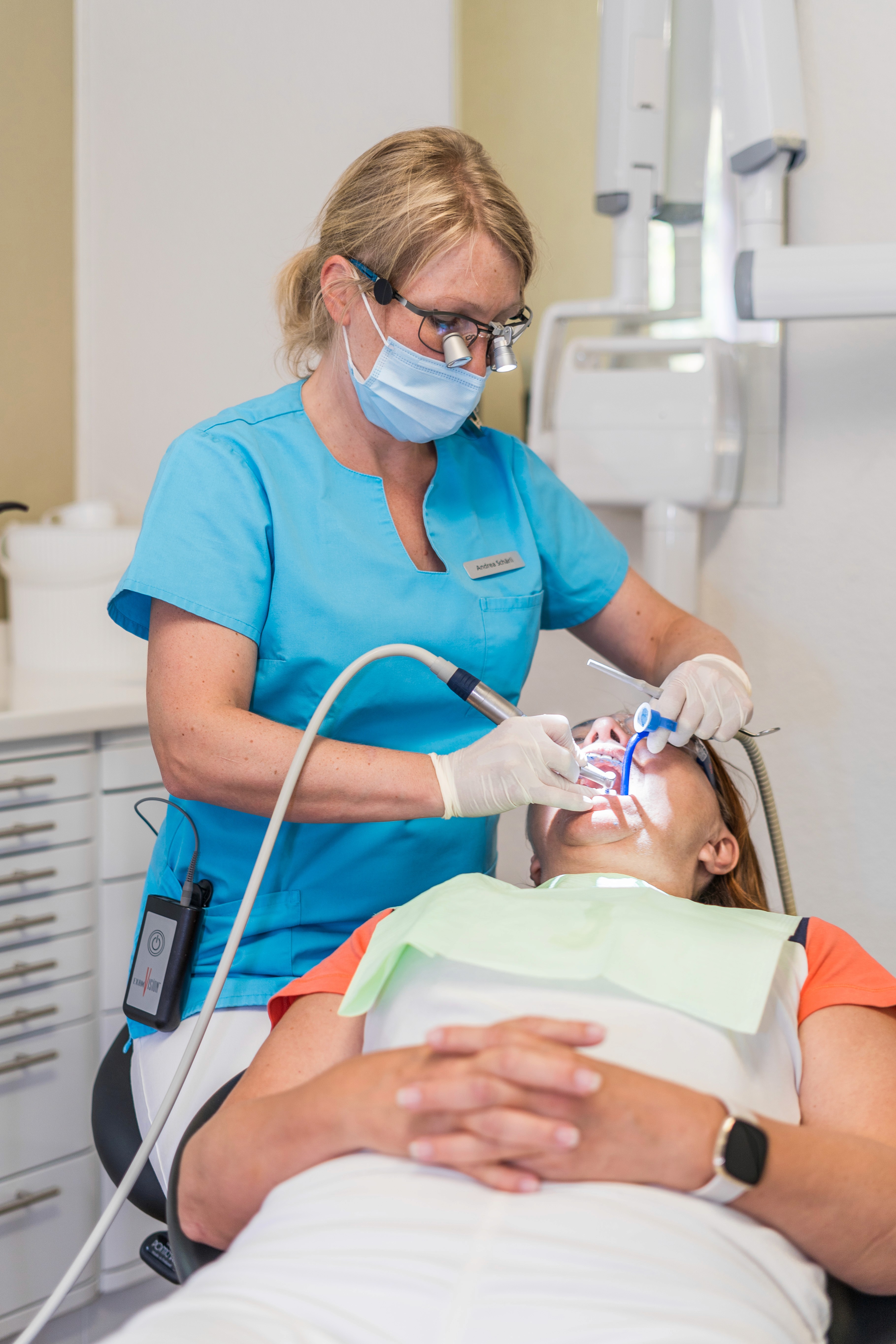 Dentalhygienikerin führt professionelle Zahnreinigung bei Patientin durch.