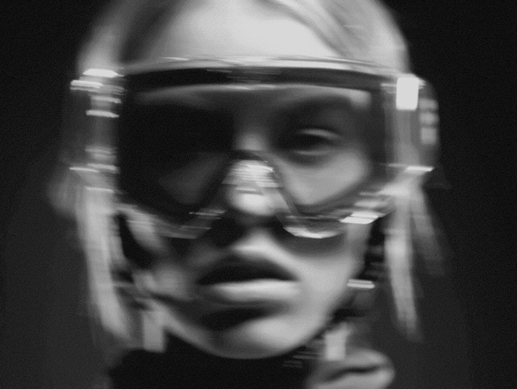 A helmeted figure with tactical gear and a direct powerful gaze