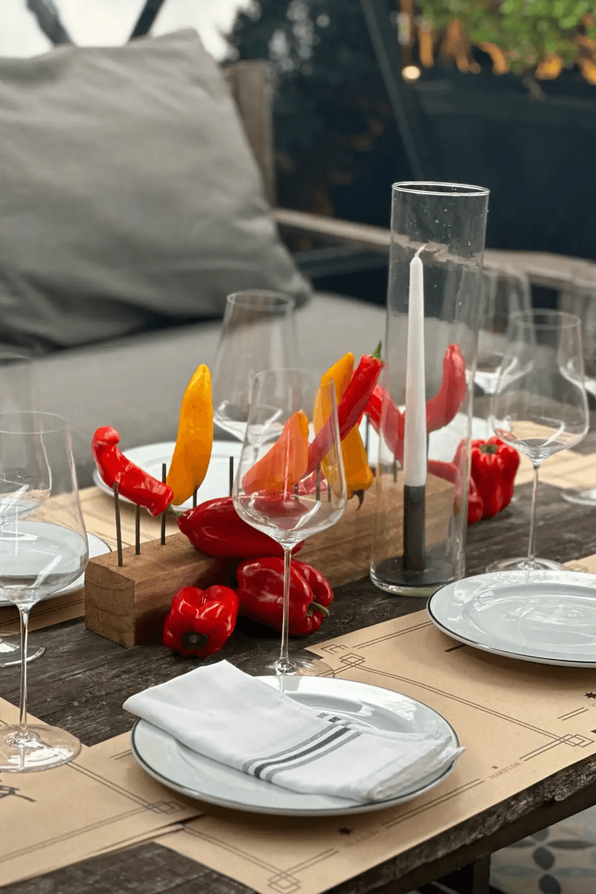 Detalle cercano de musgos y ramas con textura vaporosa en tonos verdes y beige sobre mesa elegante.