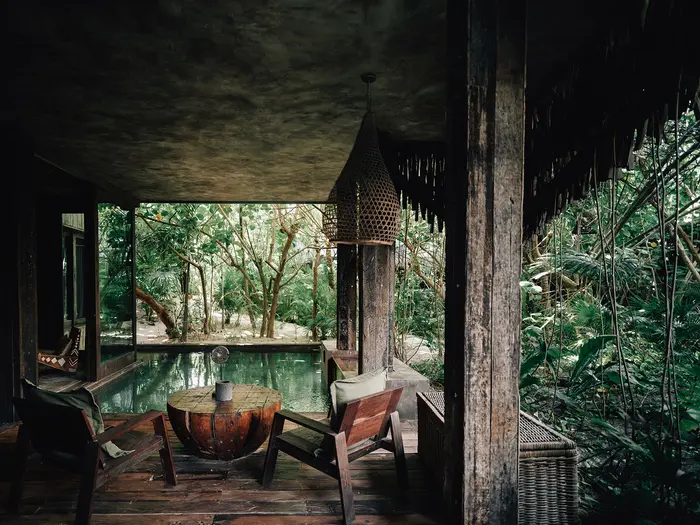 Fuego Suite at Nômade Tulum highlighting seating area with chairs and table, jungle view, and private pool.
