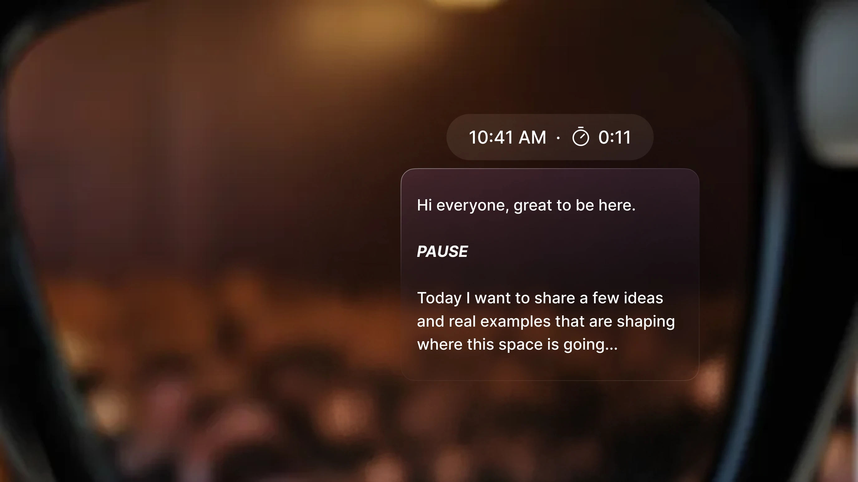 Point-of-view shot through smart glasses showing a teleprompter overlay in the wearer's field of view. The display reads: "Hi everyone, great to be here. PAUSE. Today I want to share a few ideas and real examples that are shaping where this space is going..." A timer reads 0:11 and the time shows 10:41 AM.