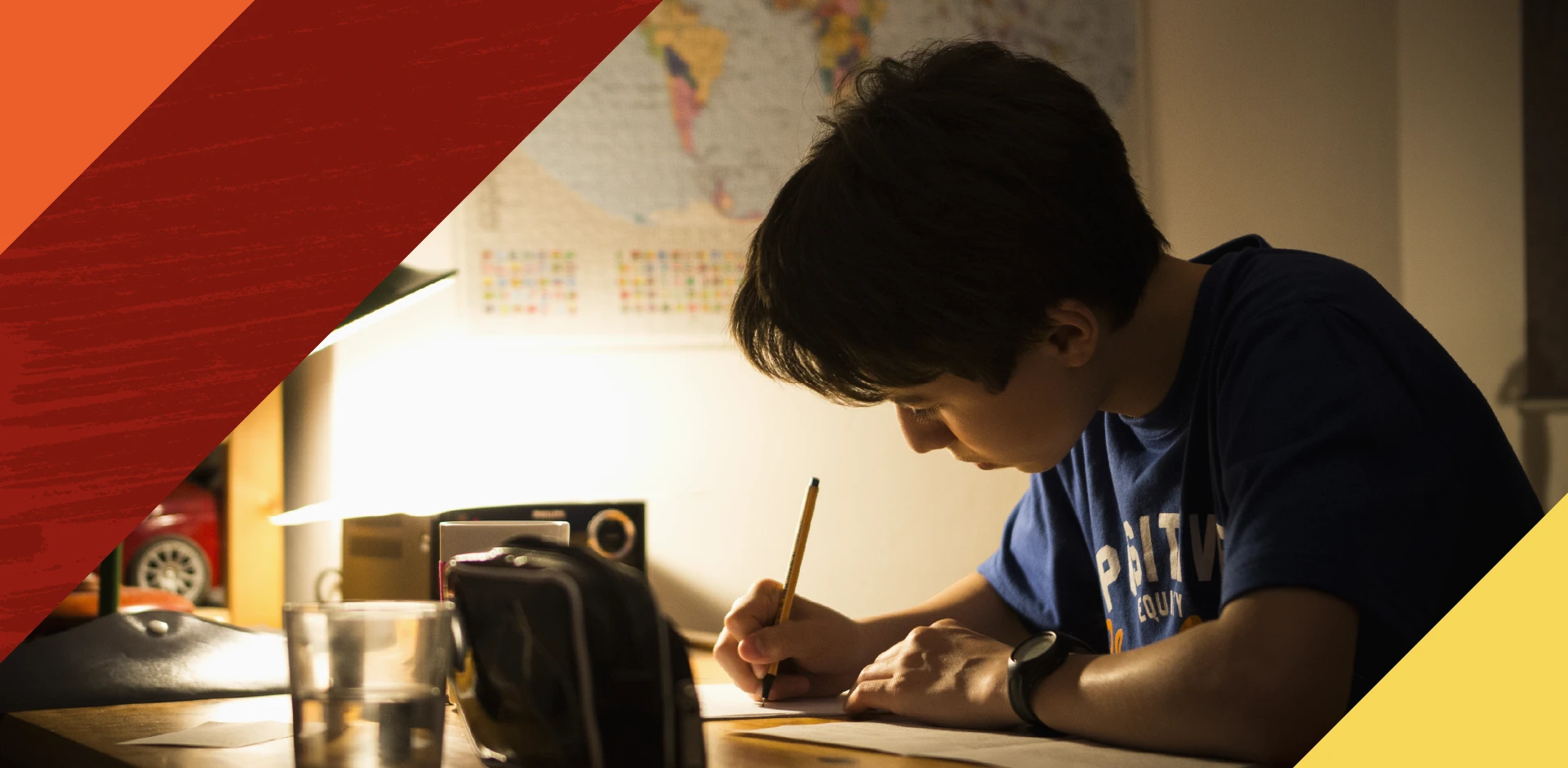 Little boy writing under dim lamp light