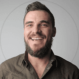 A smiling man with a beard, exuding warmth and friendliness.