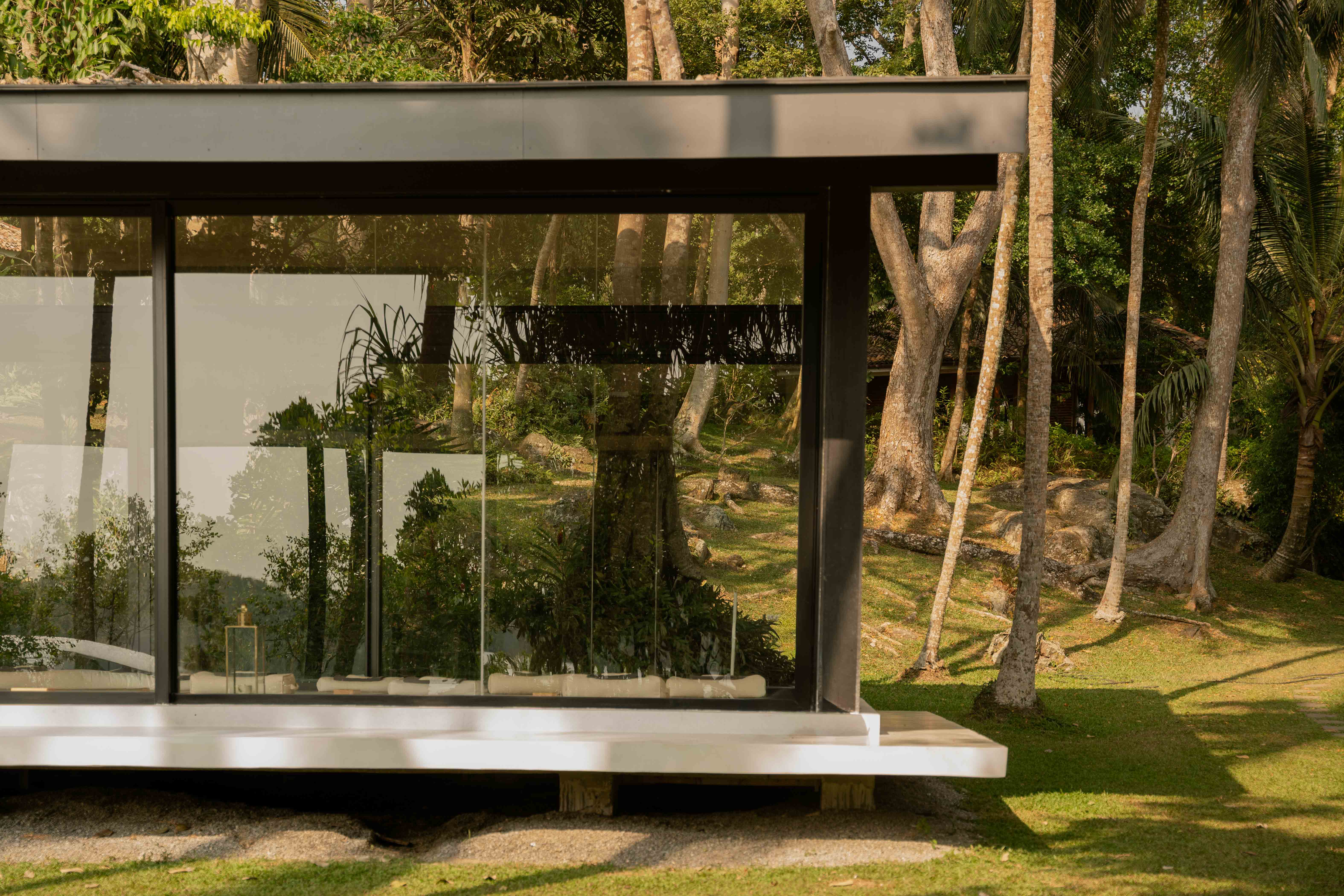 Yoga shala with glass windows surrounded by nature