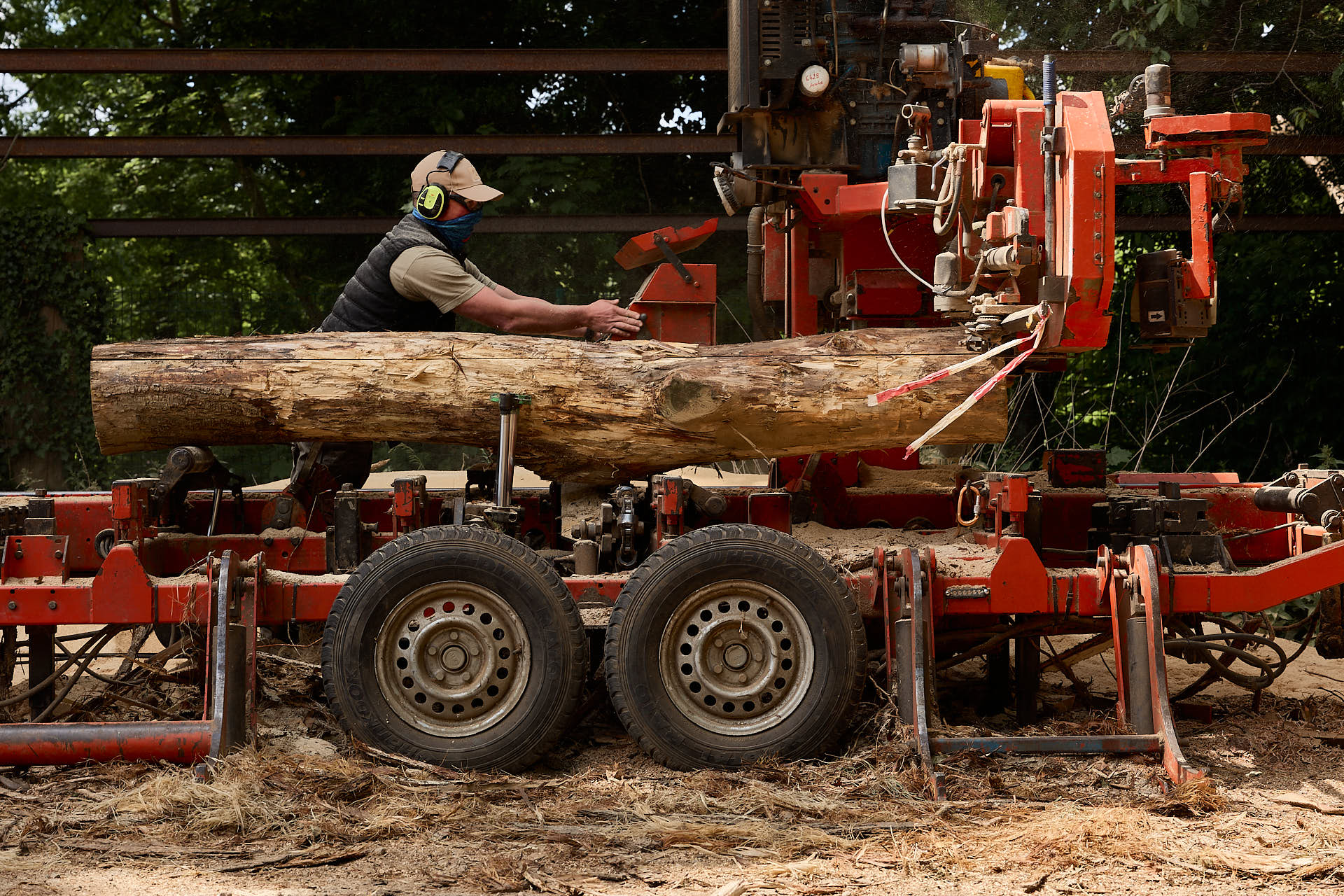 Reportage filière bois : scierie mobile en fonctionnement sur site, débitant des planches directement en forêt.