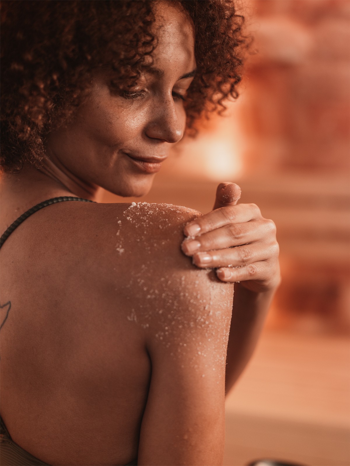 Maria reibt sich mit Salz ein in der Sauna