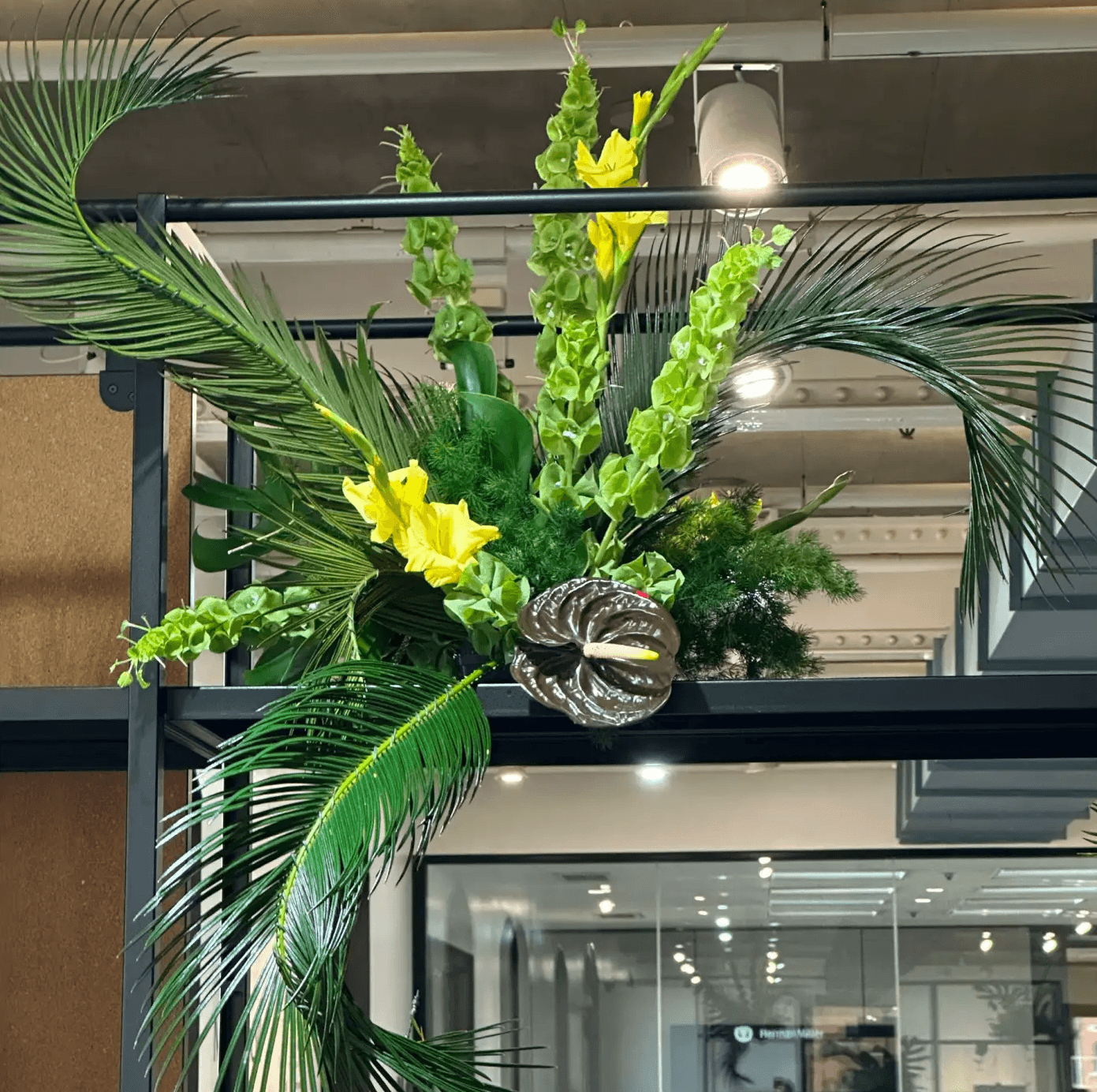 Diseño botánico contemporáneo con campanas de Irlanda, gladiolos y anturio negro sobre estructura metálica.