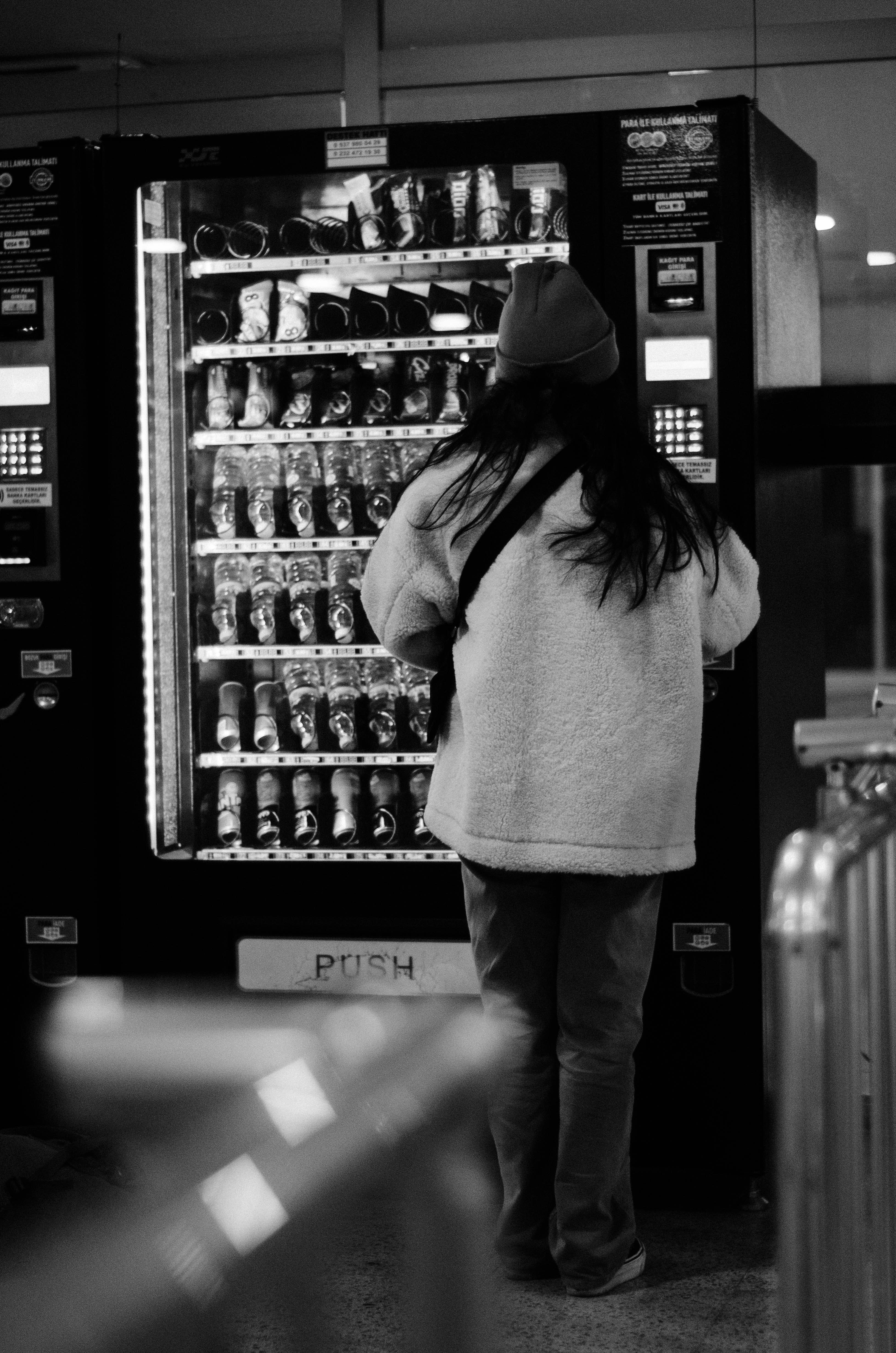 a woman standing in front of a vending machine