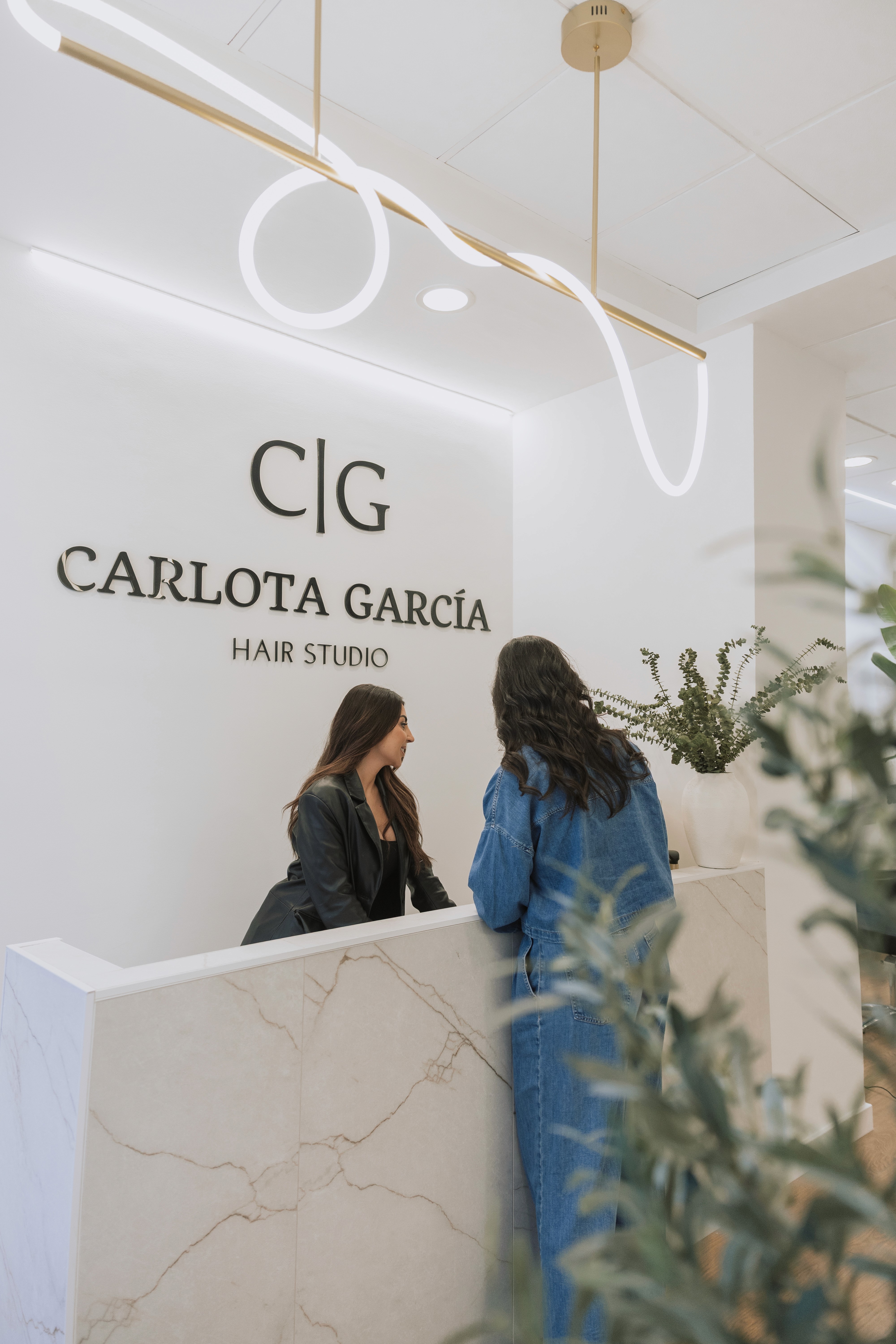 A person lying on a massage table, their face covered with a towel, bathed in warm golden light. The setting exudes relaxation and comfort.