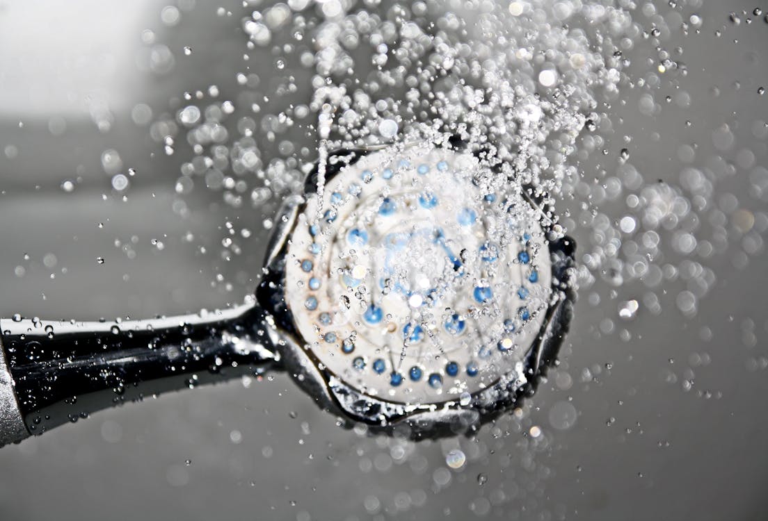 water flowing from black shower head