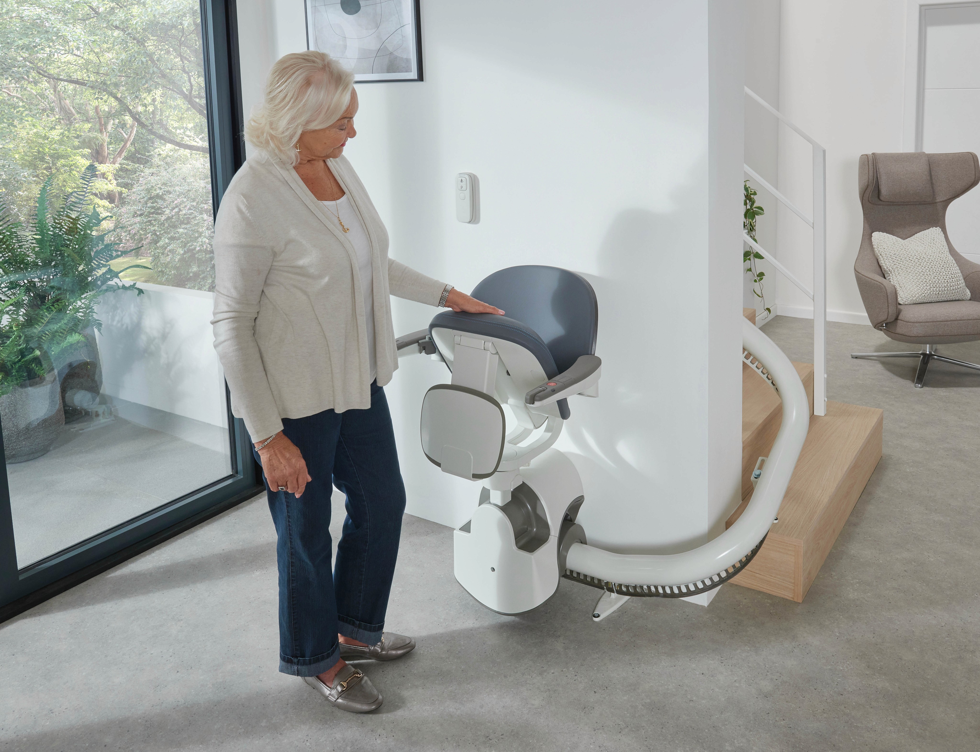 A woman inspecting the stair lift product within a home