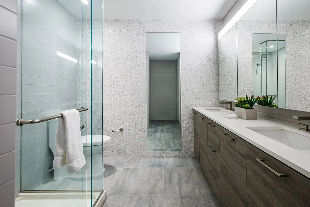 A sleek modern bathroom featuring glass shower doors and contemporary fixtures.