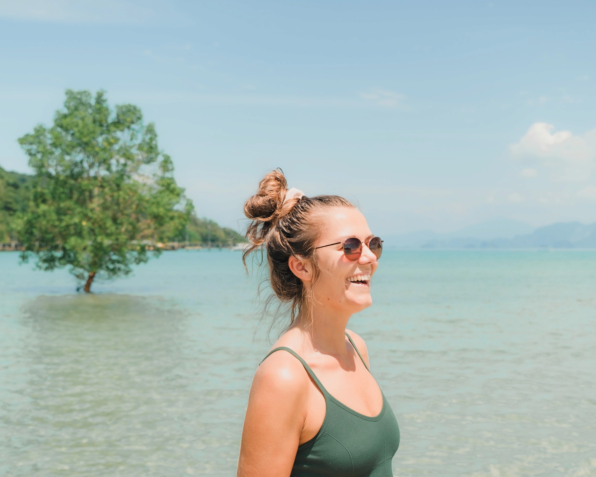 eva standing in shallow coastal waters with a mangrove tree in the background.