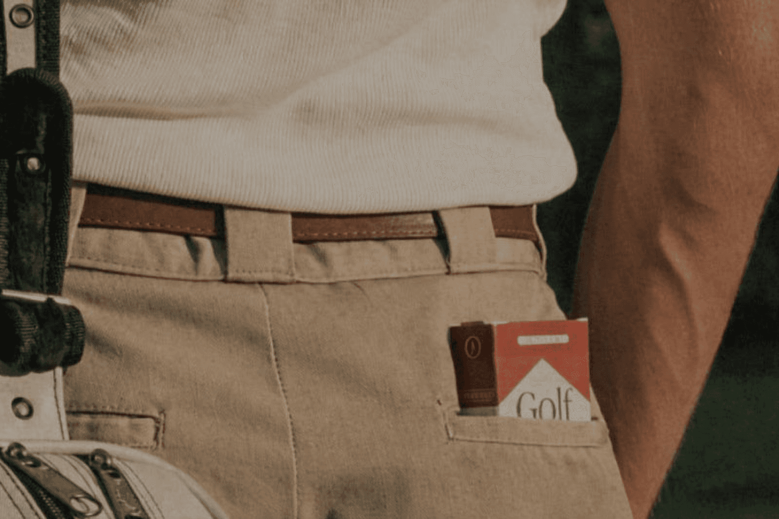 Man dressed in dark casual wear sitting alone in a stadium’s empty rows of purple chairs, lit by dramatic moody lighting.