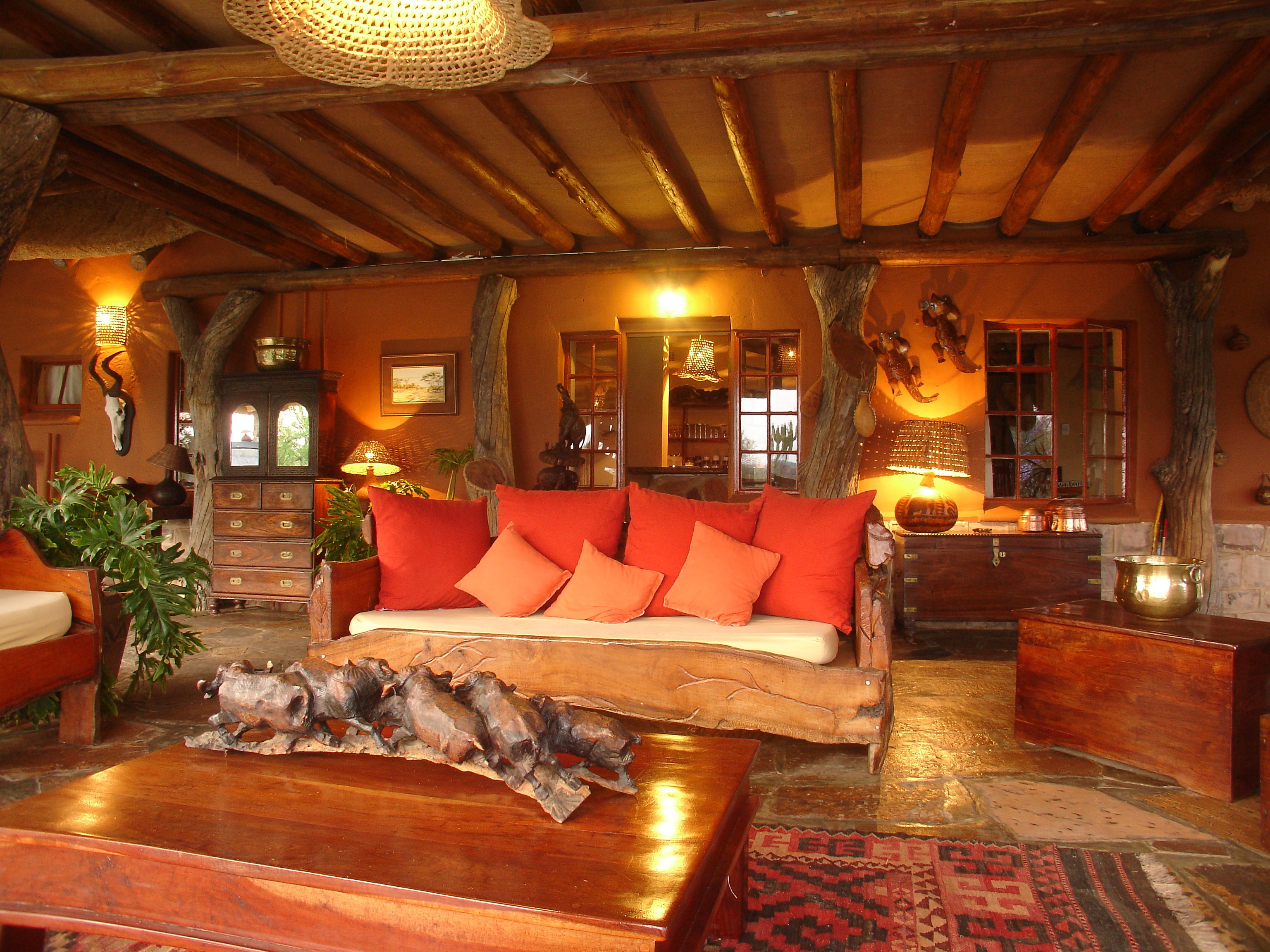 Grupp av ryttare på ridresa i Afrika galopperar över Serengetis vidsträckta slätter medan damm och gnuhjordar rör sig över horisonten under the great migration.