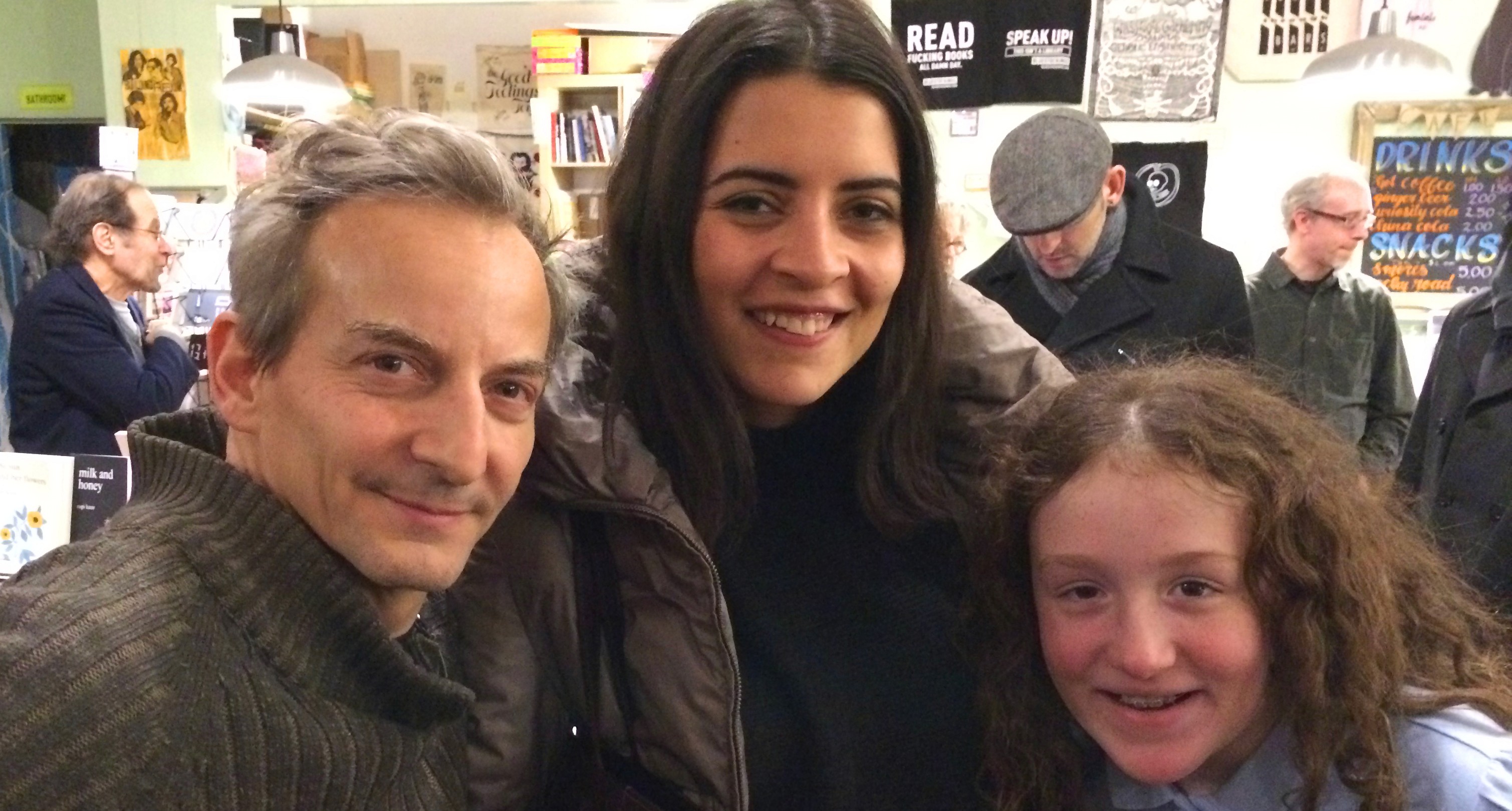 A photo of three people siting in a shop.