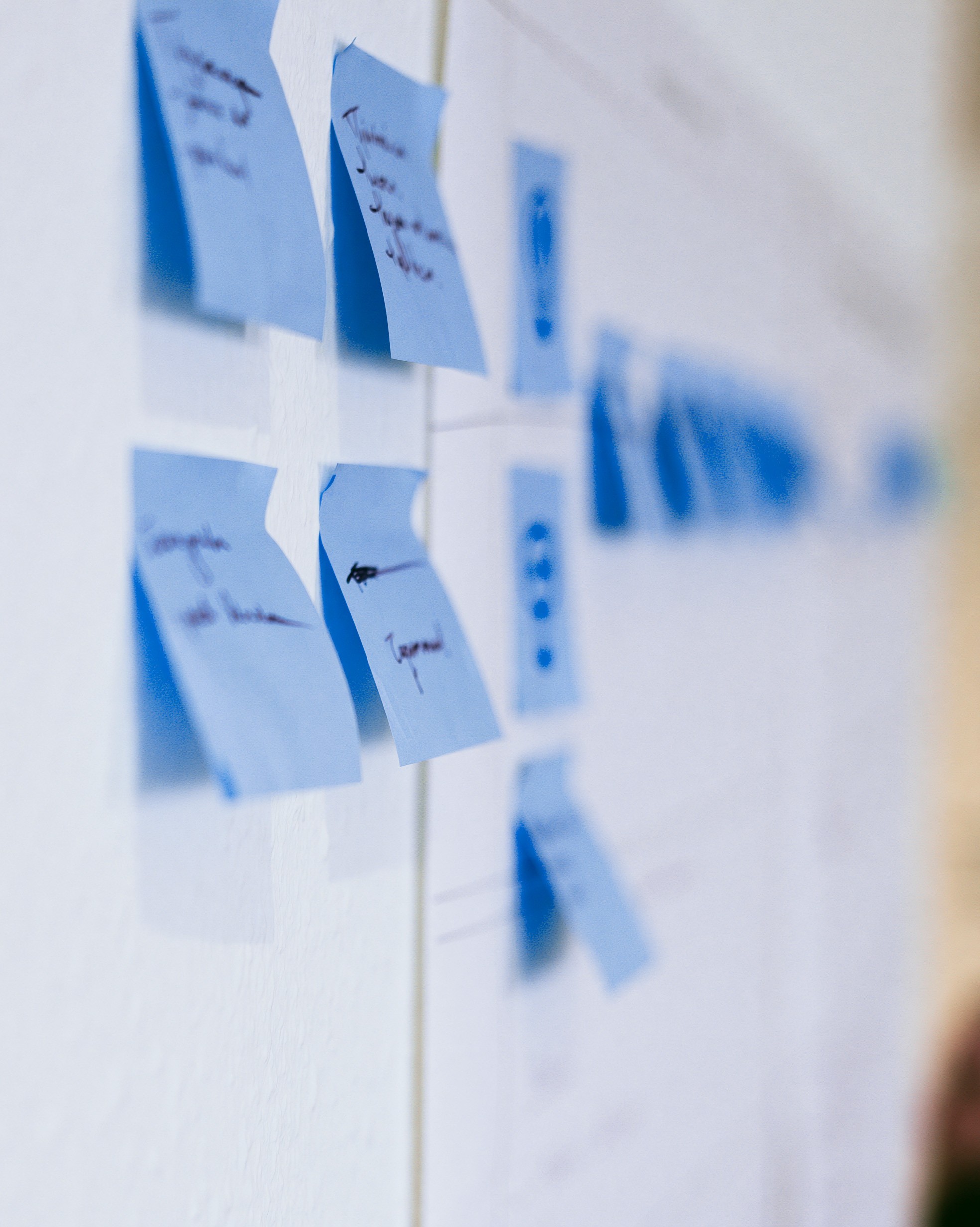 Hellblaue Post-Its an einem White Board, die die Entwicklung einer Markenstrategie unterschreichen sollen