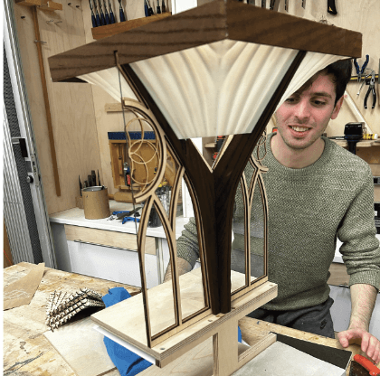 Curved 3D printed panels are hung from the laser cut plywood.