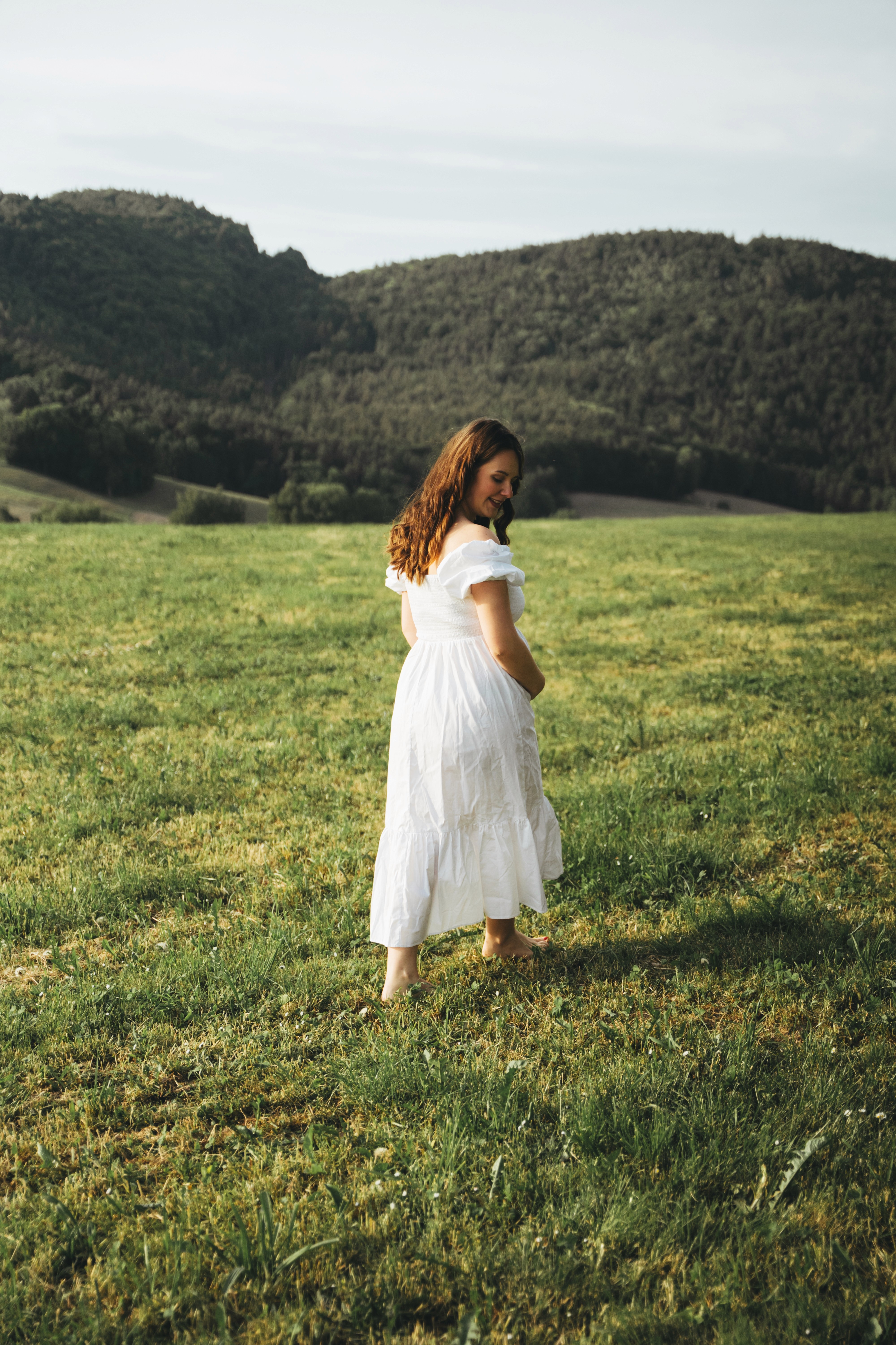 Schwangerschaftsfotografie Outdoor in Bogen, Niederbayern – werdende Mutter auf einer Wiese im Abendlicht.