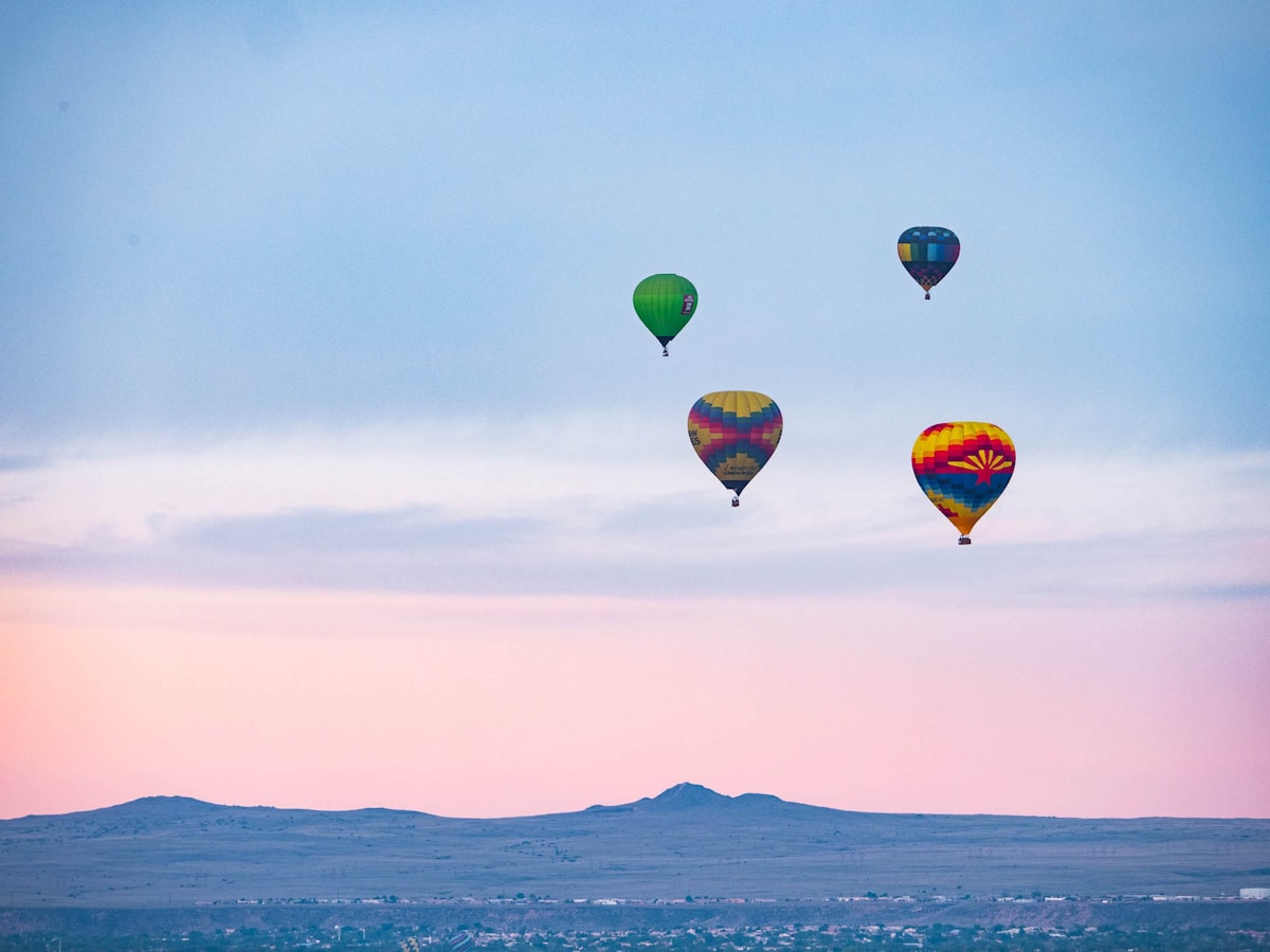 Hot air balloons rising at dawn over the New Mexico desert