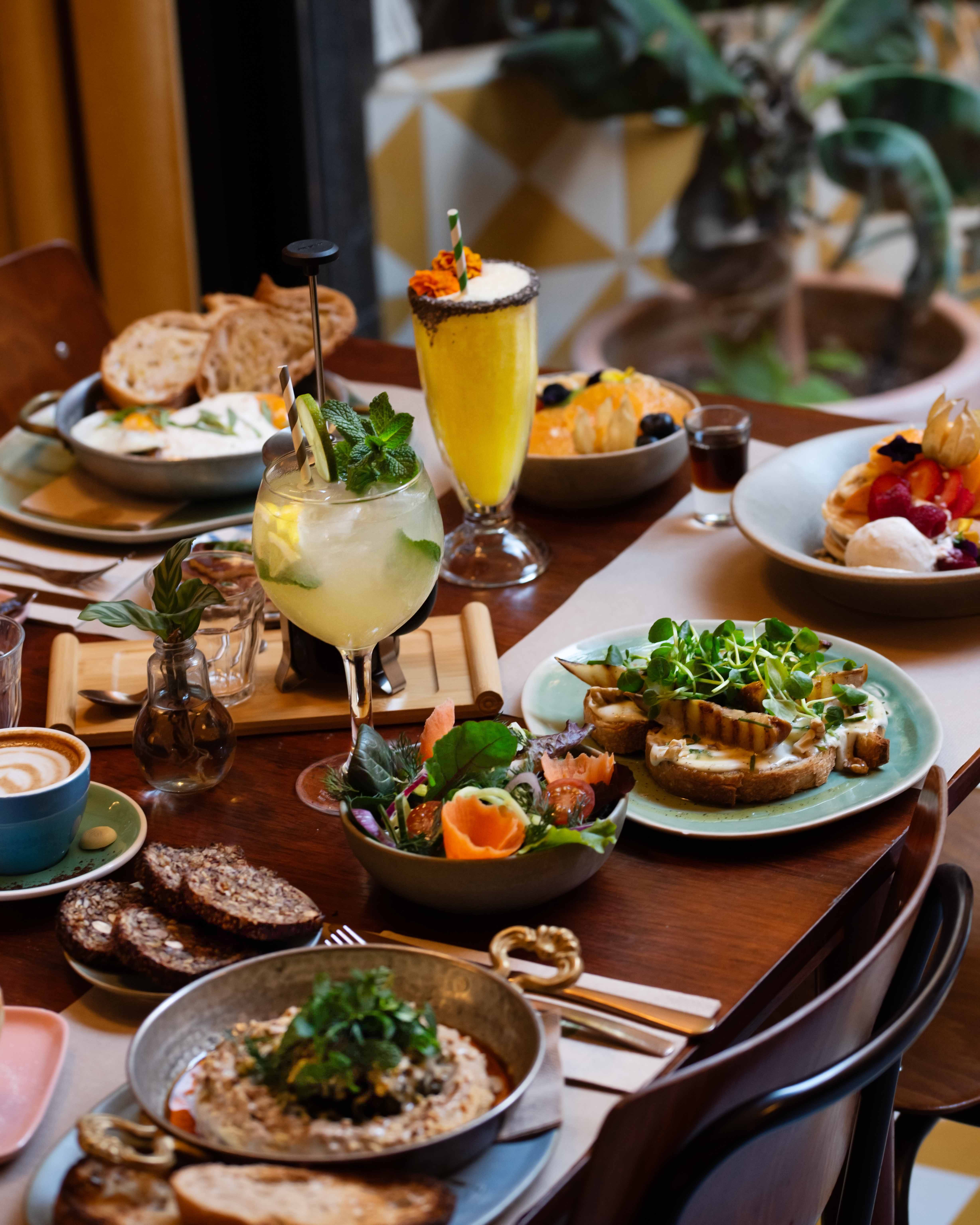 Vegetarian brunch table with cocktails and specialty coffee at Faire. Brunch & Drinks