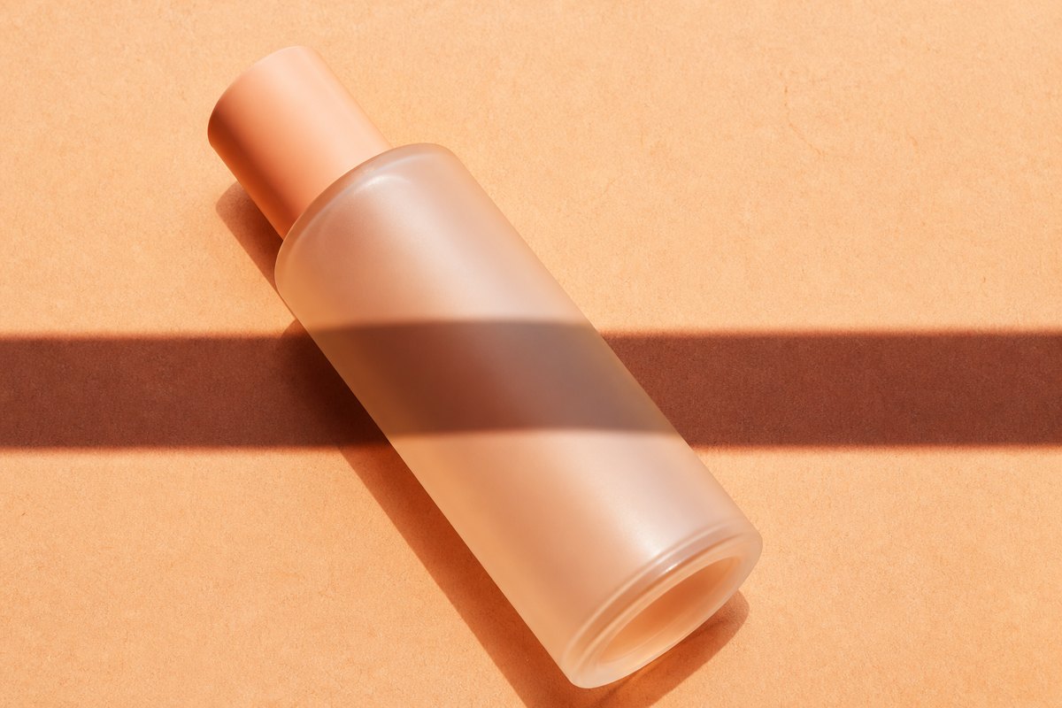 Unbranded Korean skincare bottle showing its blank information panel in raking sunlight
