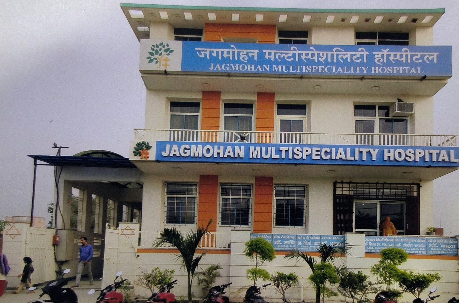 Jagmohan Multispeciality Hospital near Loni Toll Plaza — a three-storey building with blue bilingual signboards and orange columns