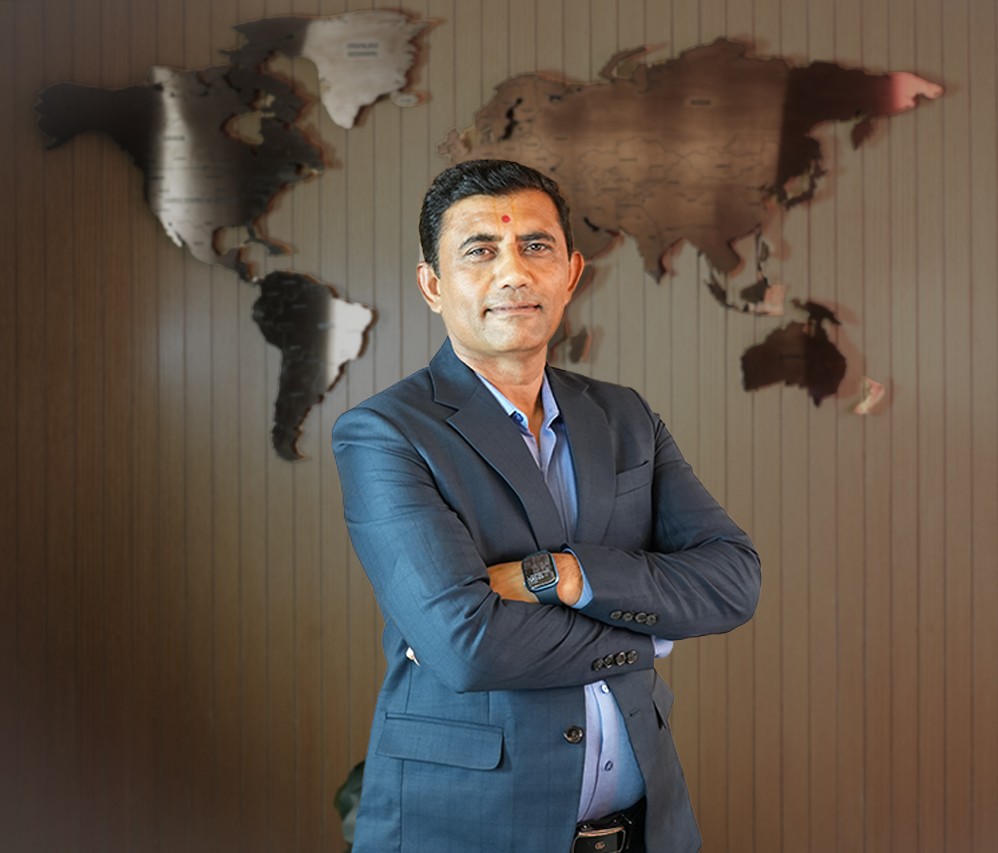 A man in a suit sits at a desk.