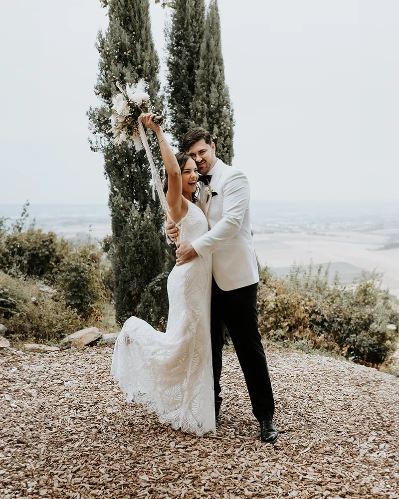 Ausgelassenes Brautpaar vor toskanischer Landschaft mit Zypressen, Destination Wedding Fotografie von Eva Sitko