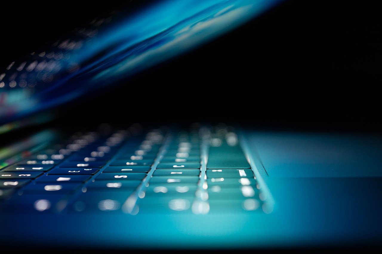 Laptop half closed with a green/blue light emitted from the screen