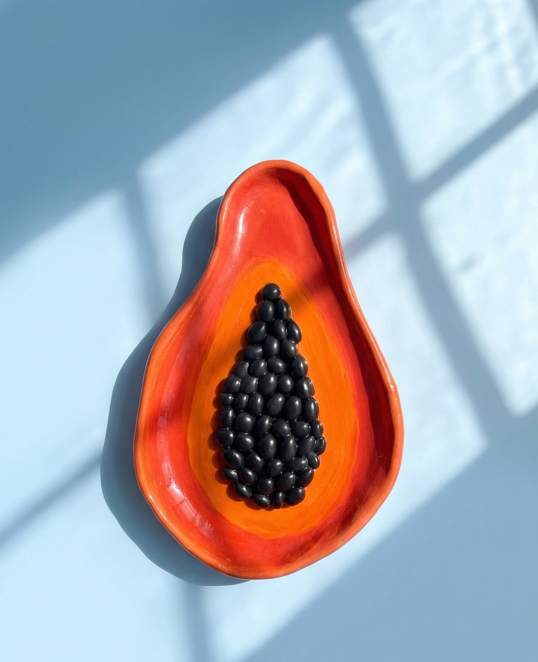a ceramic plate shaped like a papaya fruit