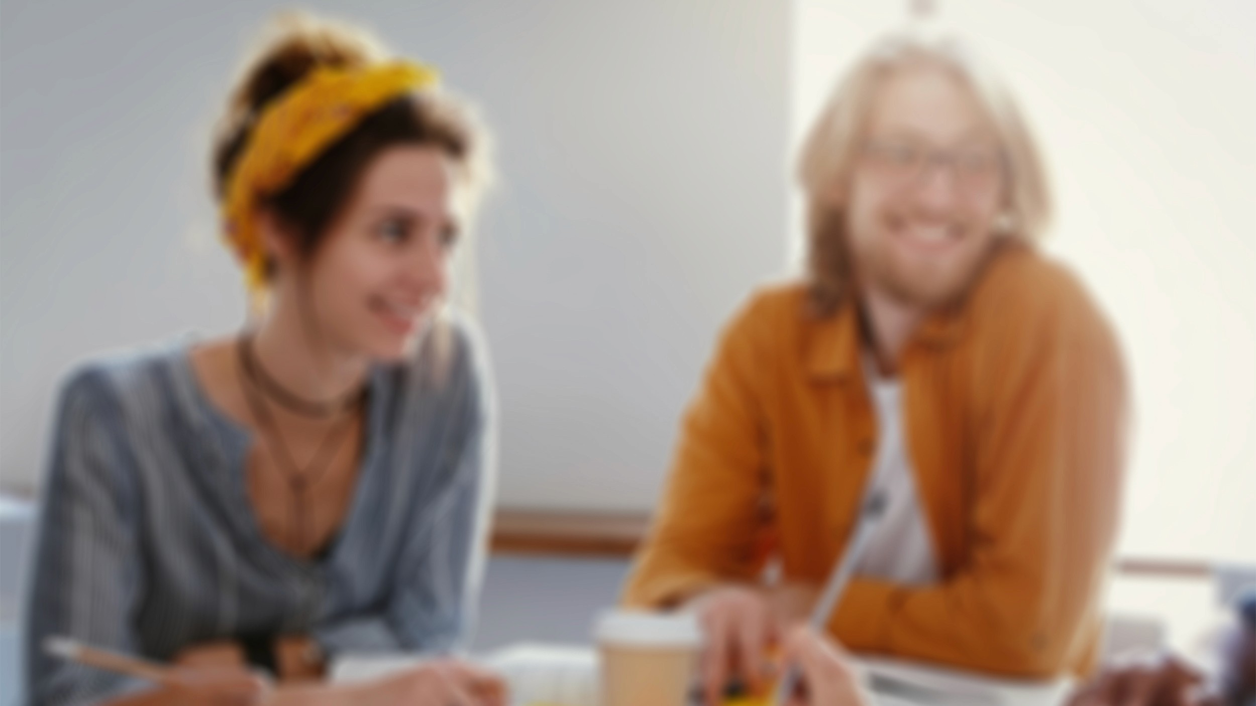 Záběr na usměvavé tváře lidí v přátelském rozhovoru, symbolizující lidský přístup, otevřenost a pozitivní energii týmu.