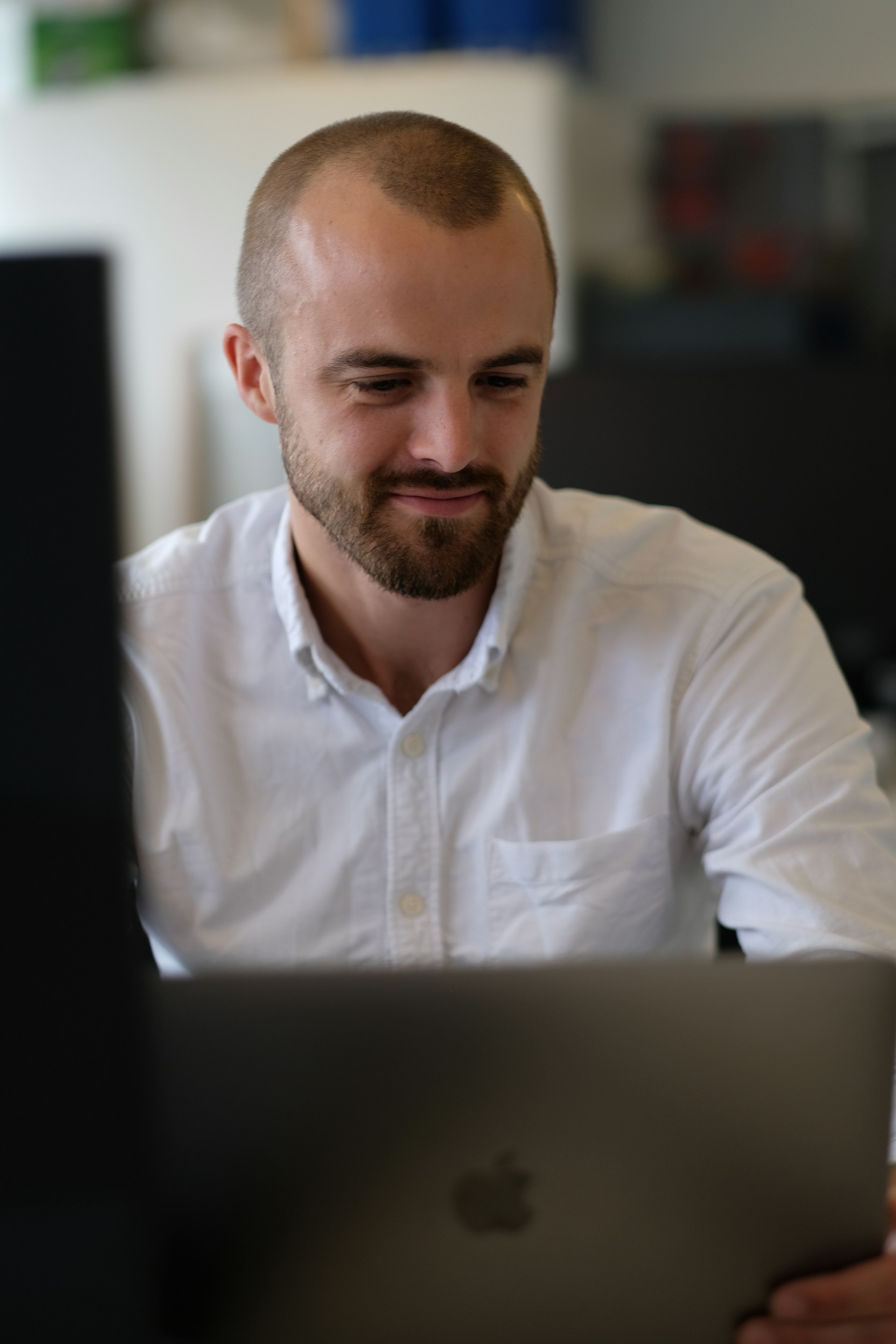 A man in white shirt looking at the screen