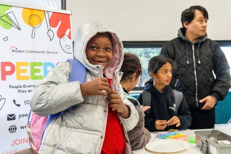 A child smiling at the camera at a community event