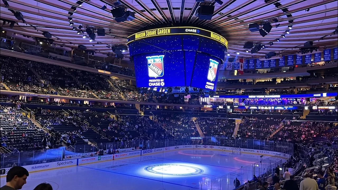 Full arena view of Madison Square Garden during a live New York Rangers game with fans filling every seat.