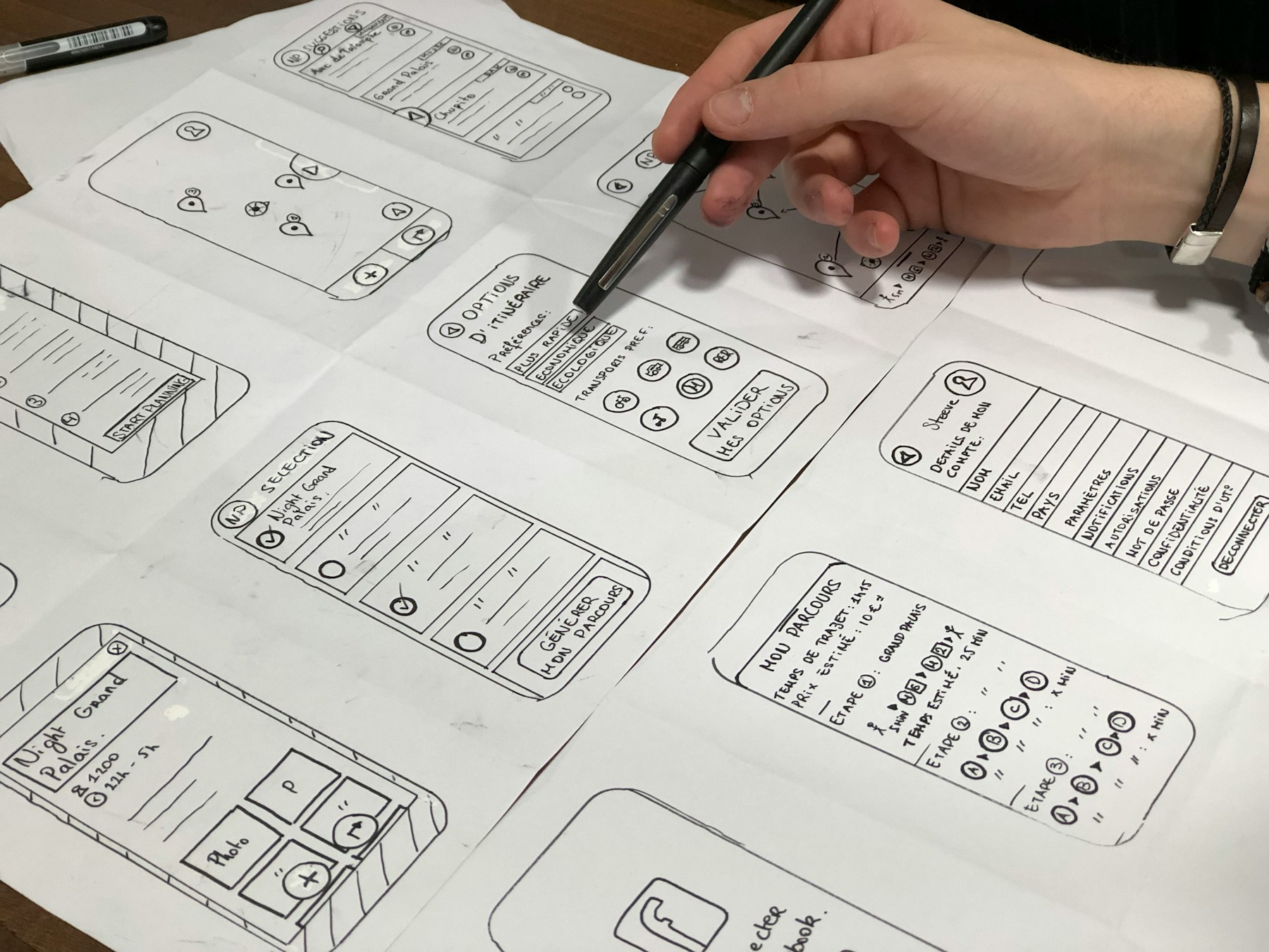 A product designer mapping mobile flows and interface decisions on paper.