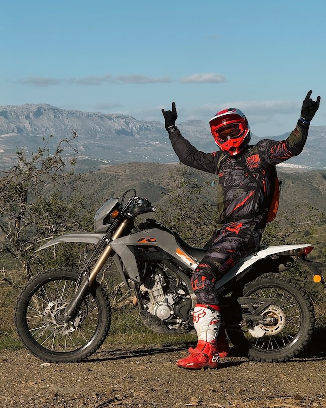 Эндуро мотоцикл едет вдоль побережья Испании на закате — тур Lepei.tours, свобода, море и приключение.