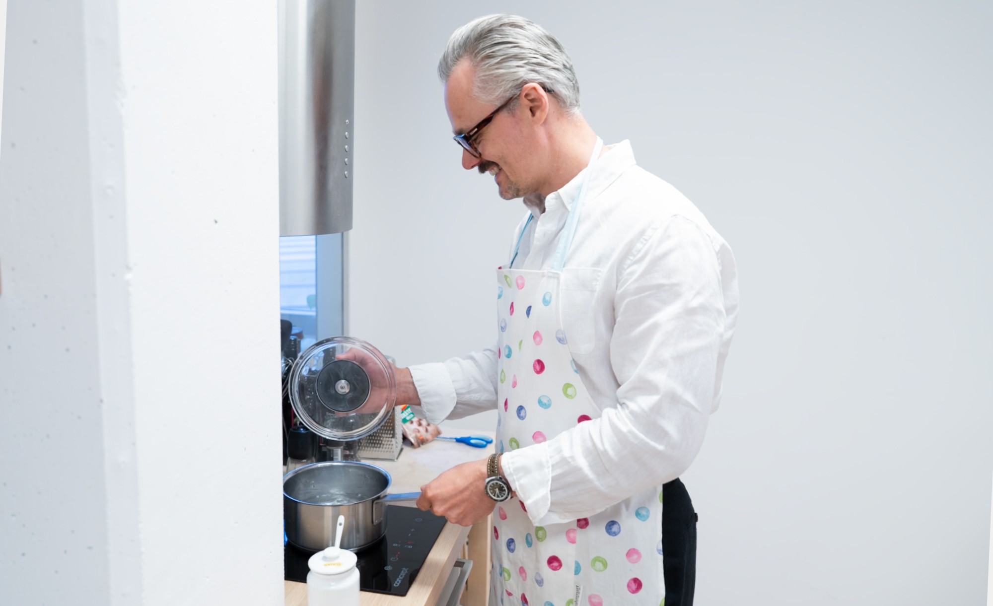 Lukáš Rychtecký in an apron, boiling water on a stove