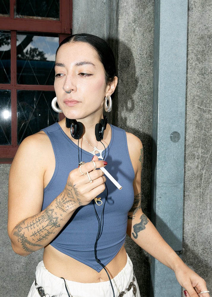 woman smoking a cigarette wearing silver jewelry
