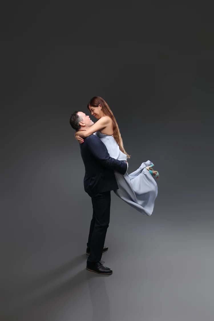 Couple embracing in a dark studio setting
