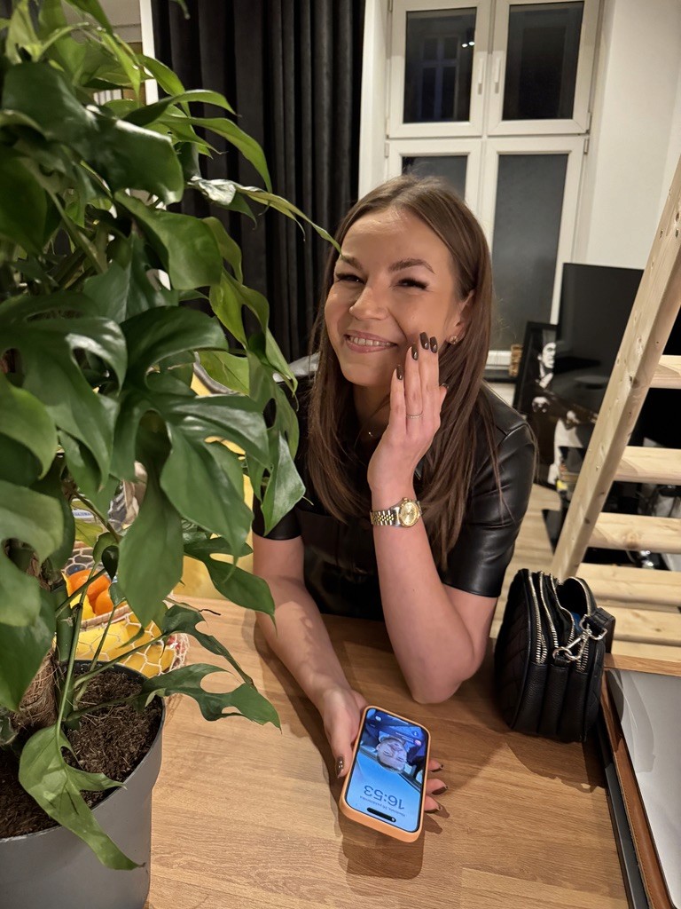 Portrait of a young man with short hair, wearing a dark t-shirt, against a plain background.