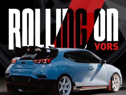 Black, modern showerhead with water droplets and soft lighting.