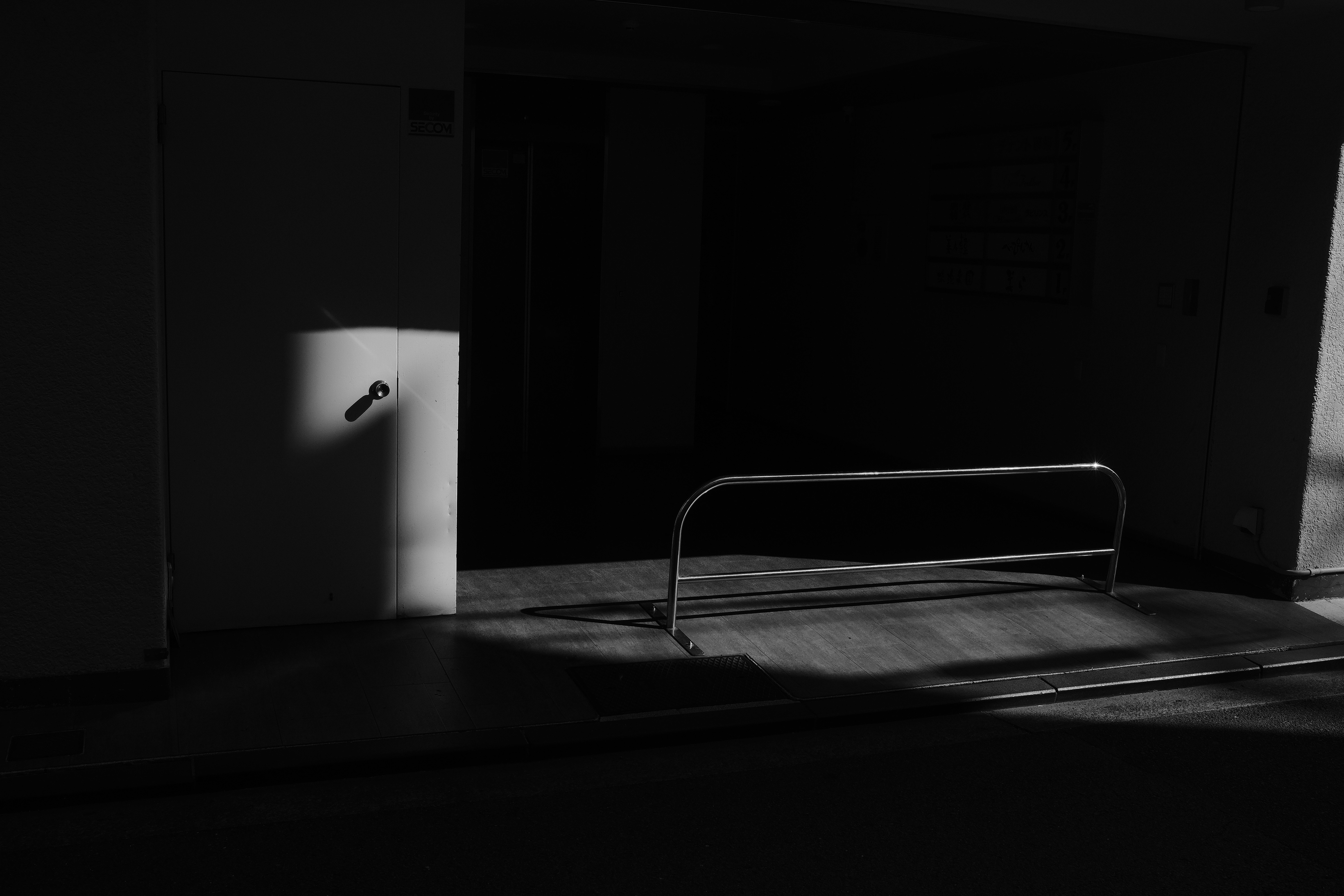 Dark room with light casting shadows on wall.