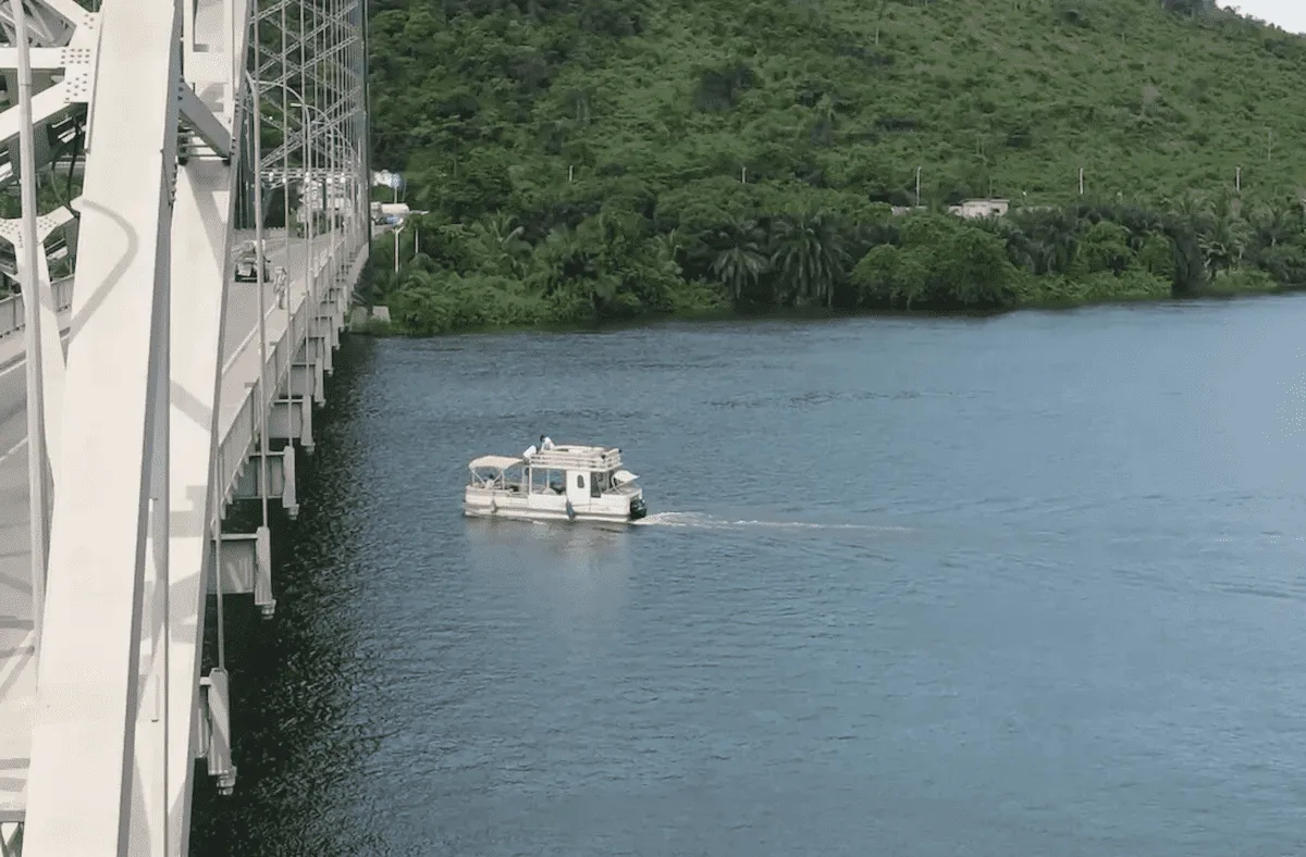 Tour boat cruising beneath Adomi Bridge on the Volta River.