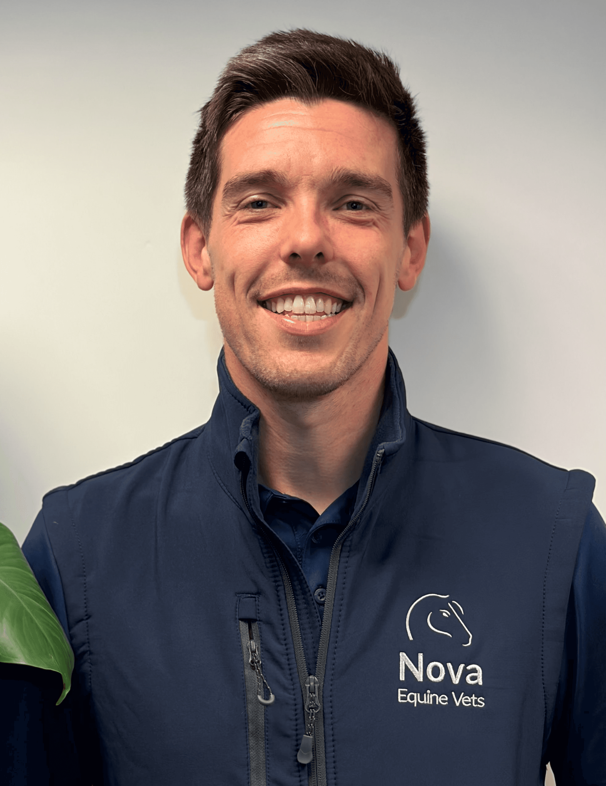 a man in a blue shirt smiling at the camera