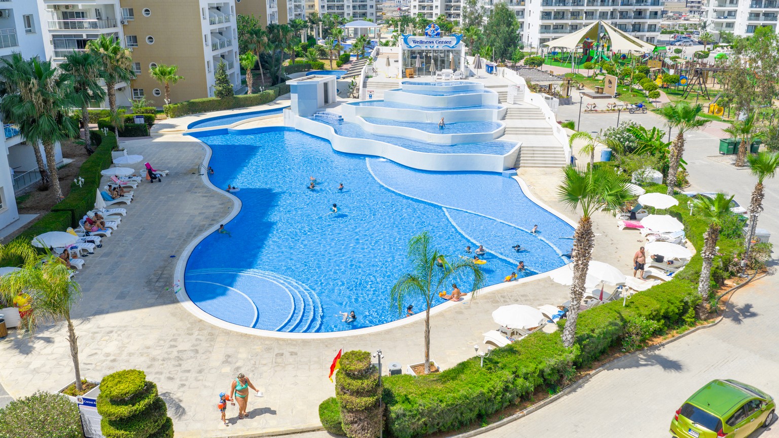 Dimly lit room with sunlight filtering through curtains, casting shadows on a green marble table with a single plate of pasta in the center.