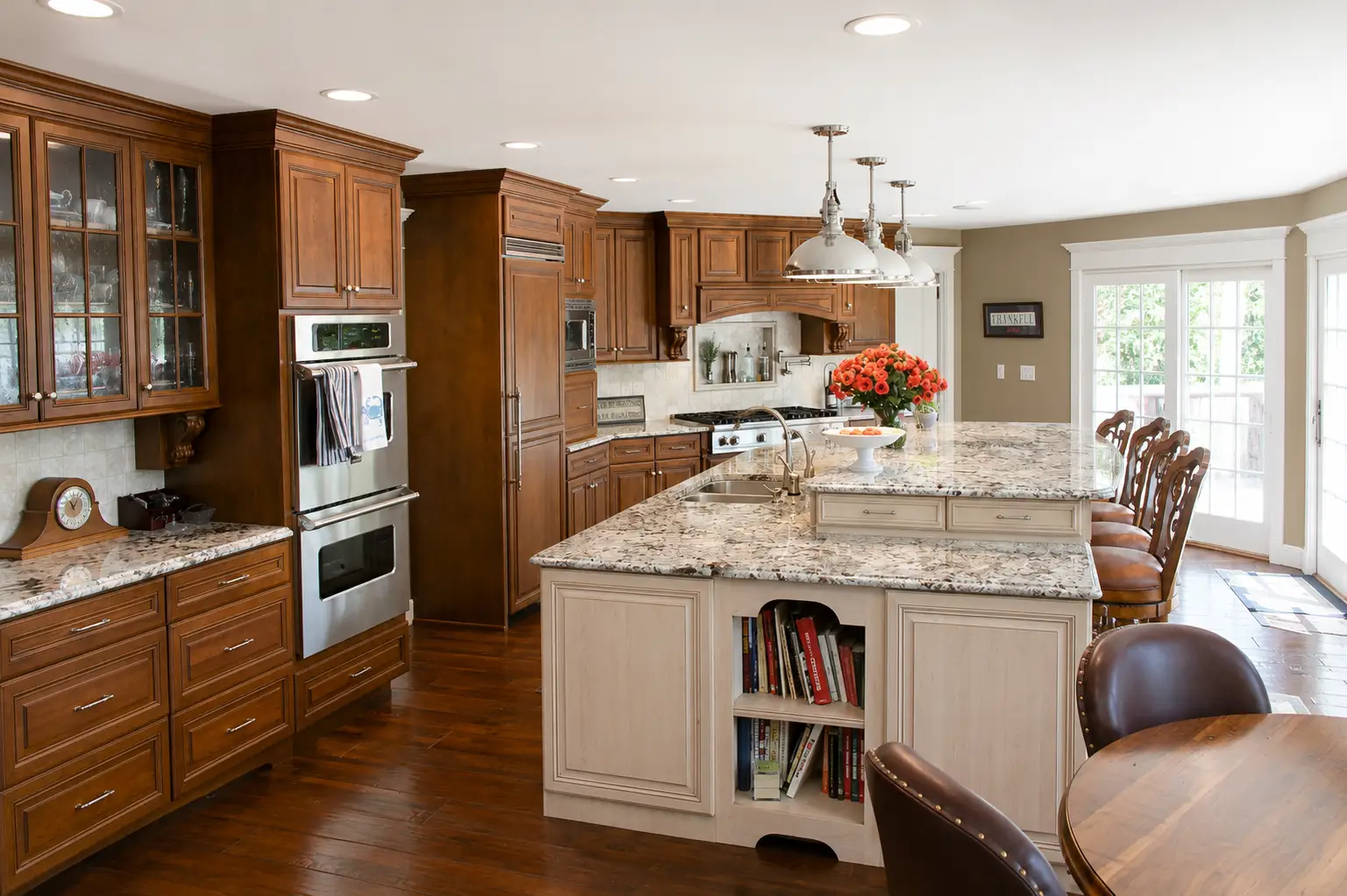Traditional kitchen with dark wood cabinets, a white center island, granite countertops, and stainless steel appliances.