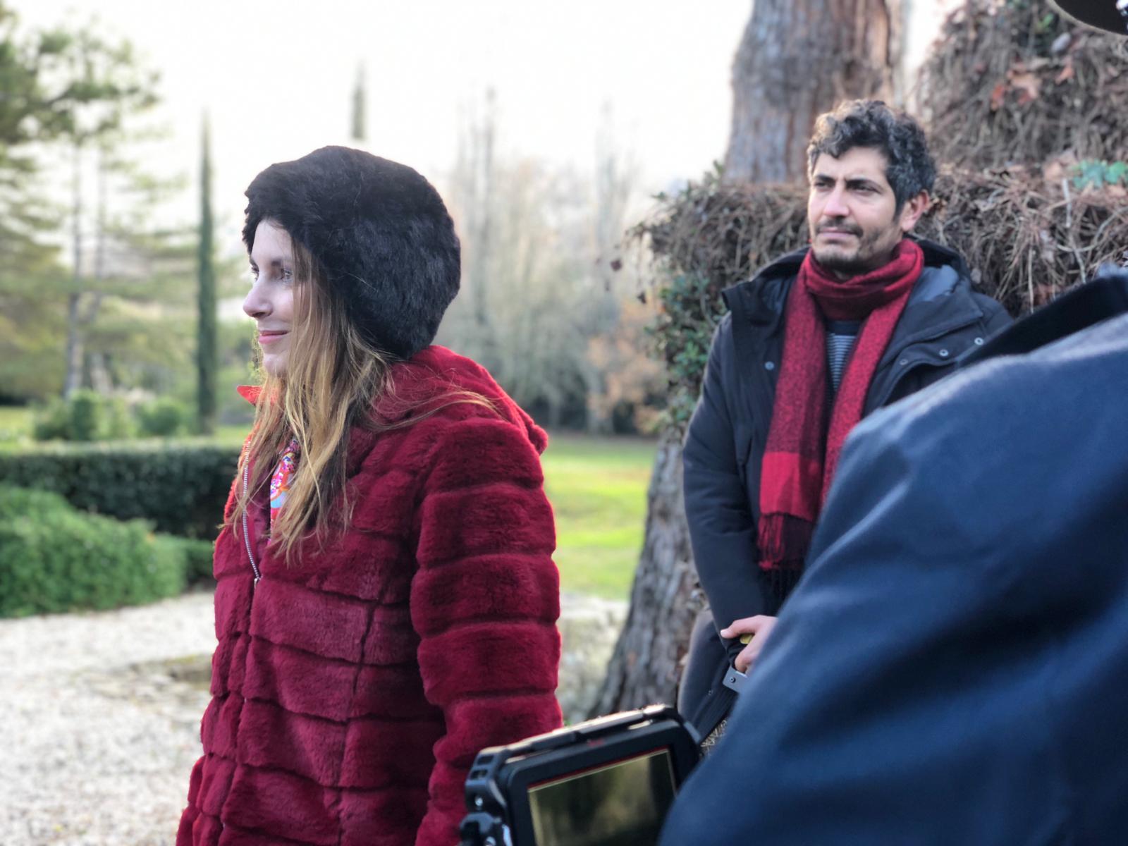 Woman in pink leather jacket crouching outdoors at night
