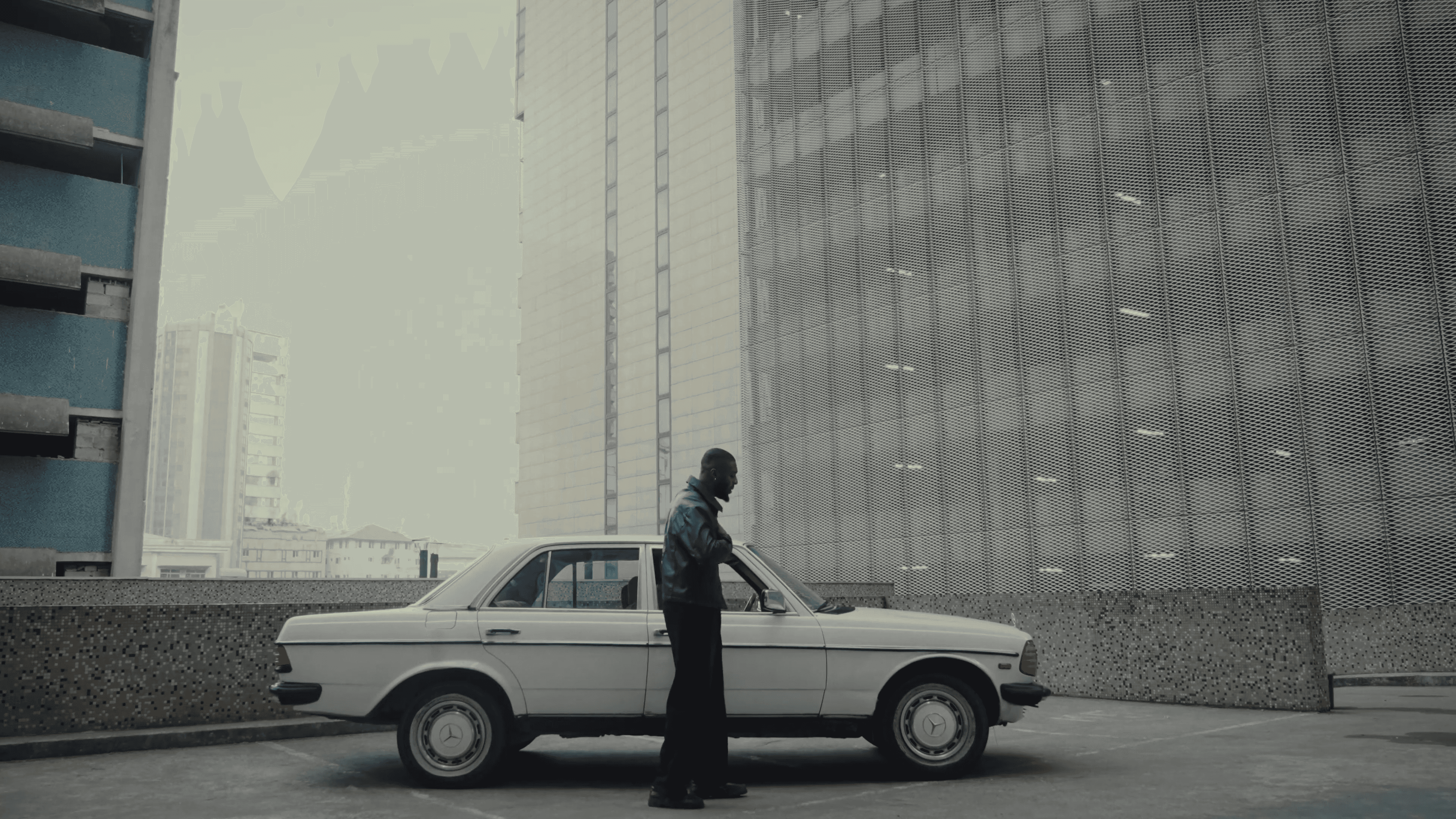 Two fathers carrying children on shoulders on a mountain path.